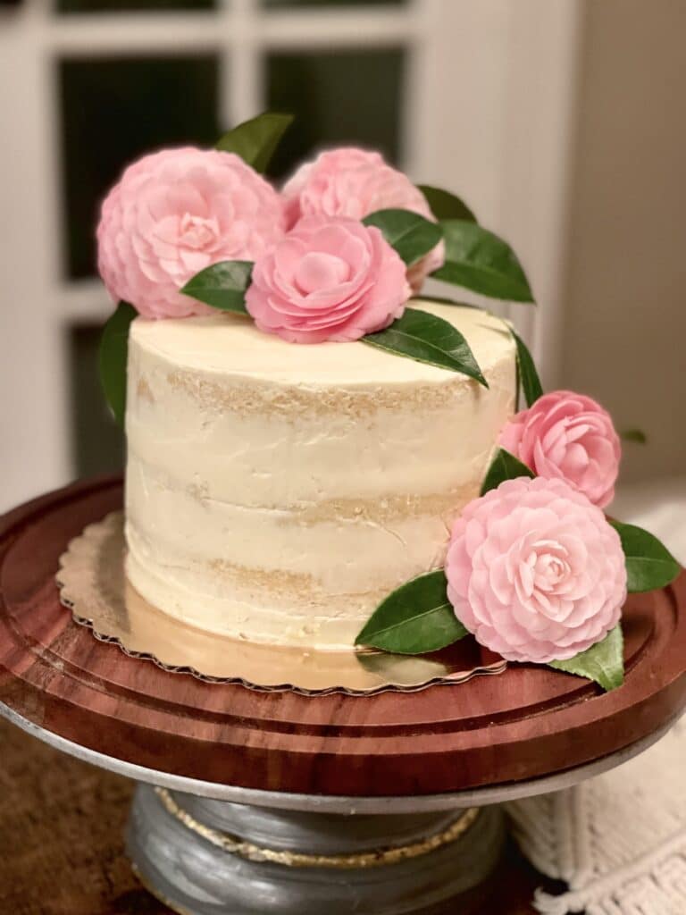 a simple white or pink cake with camellia flowers