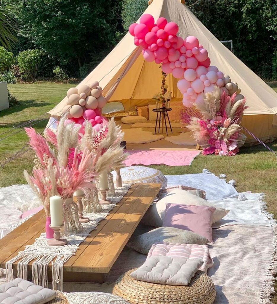 White Tent set on backyard with wooden table and boho pampas centerpiece