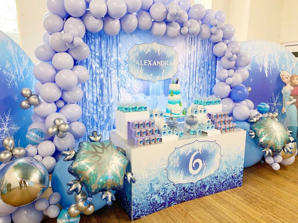 Disney Frozen Birthday Party decor with pastel blue and pink balloon arch