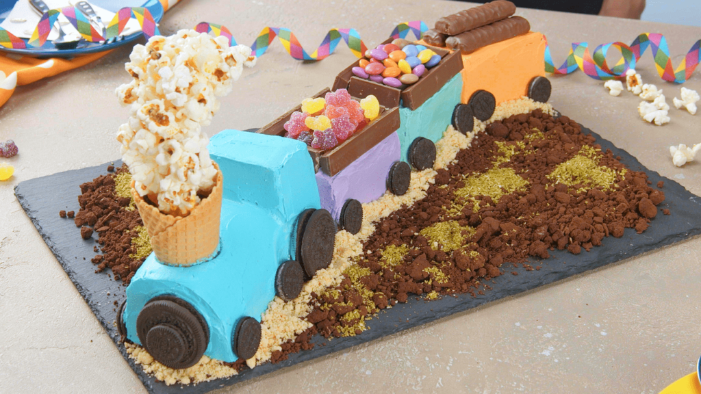 colorful yummy Steam Train Birthday Cake with Oreo wheels, Popcorn steam and candy