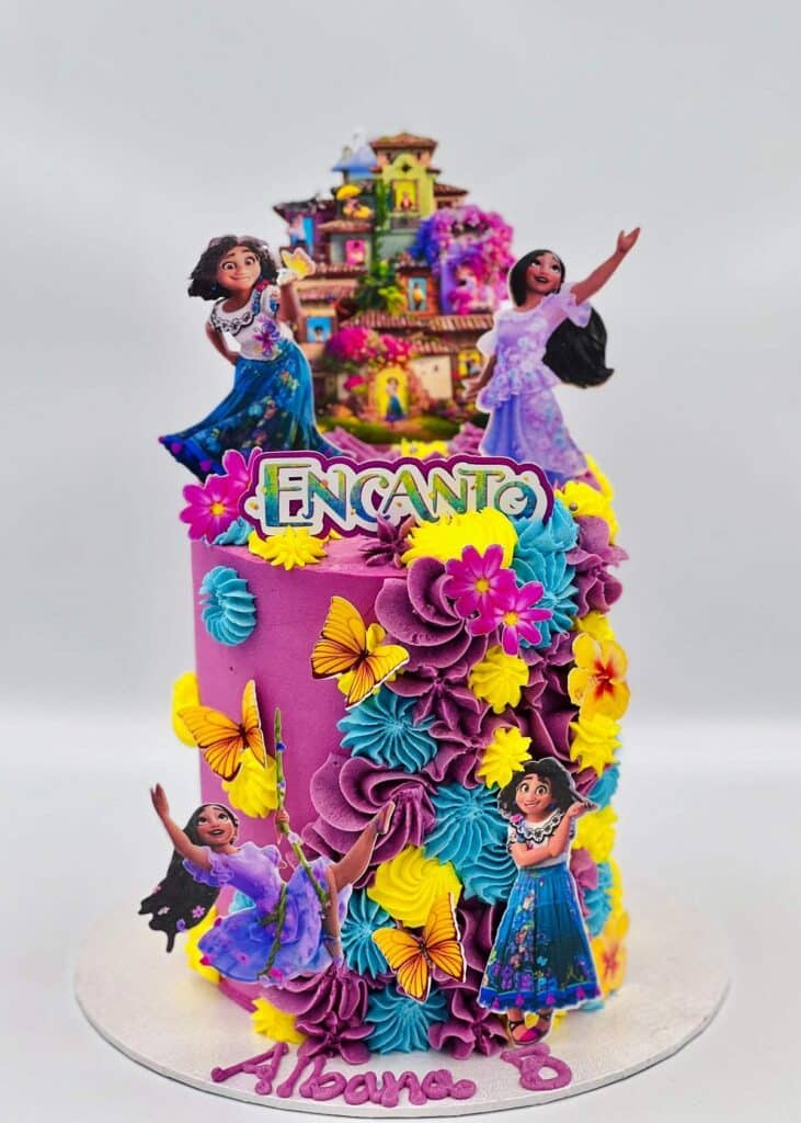 Encanto Cake with edible colorful sugar flower and Mirabel and Isabela Madrigal cake topper